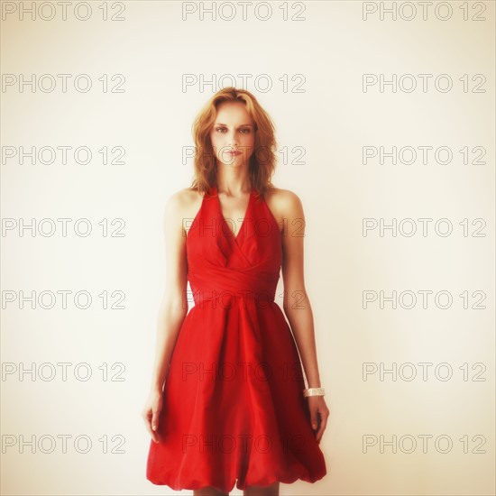 Studio portrait of young woman in red dress.