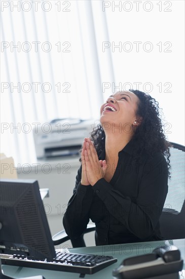 Business woman using computer and laughing.