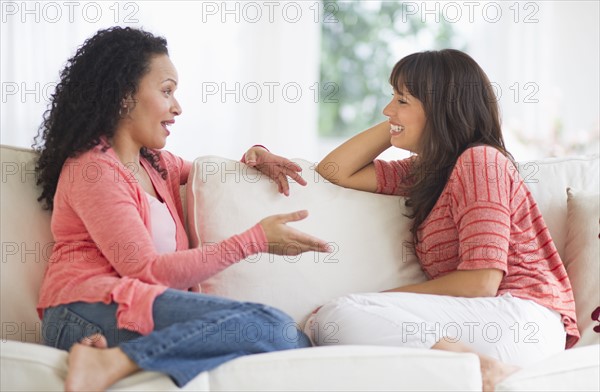 Women chatting on sofa.