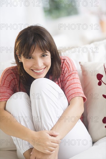 Portrait of woman sitting on sofa.
