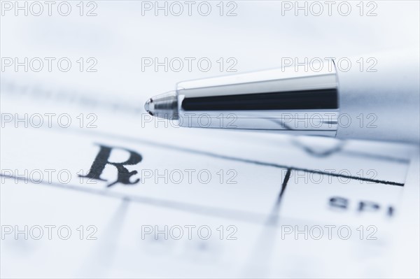 Detail of prescription with ballpoint pen, studio shot.