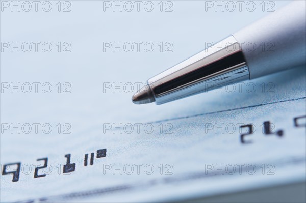 Detail of check with ballpoint pen, studio shot.
