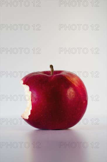 Red apple with missing bite, studio shot.