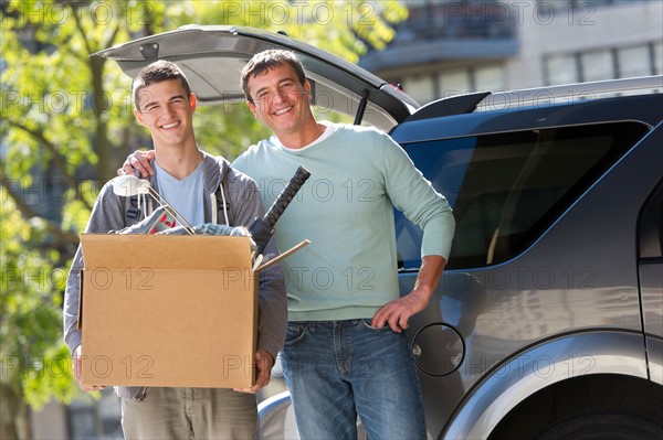 Father helping teenage son (16-17) packing to college.