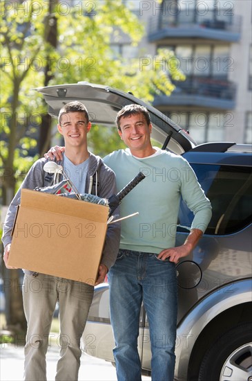 Father helping teenage son (16-17) packing to college.