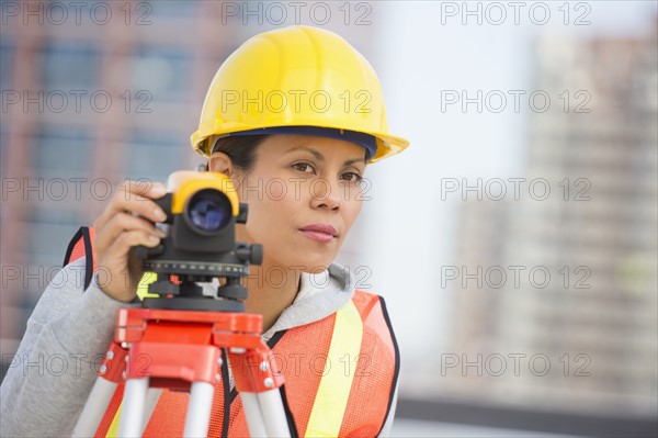 Surveyor using a theodolite instrument.