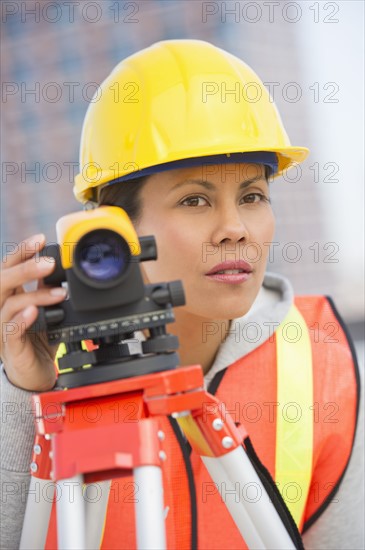 Surveyor using a theodolite instrument.