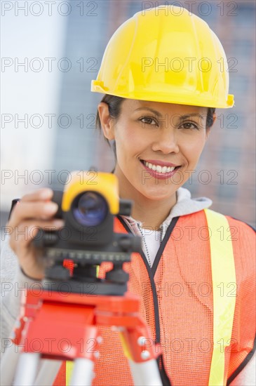 Surveyor using a theodolite instrument.