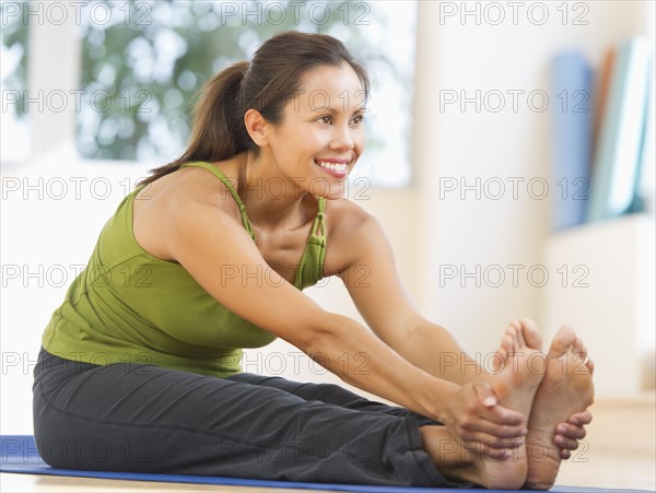 Mid adult woman training with dumbbell.