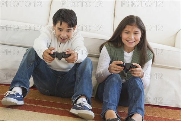 Brother (12-13) and sister (10-11) playing video games.