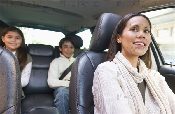 Mother with son (12-13) and daughter (10-11) in car .