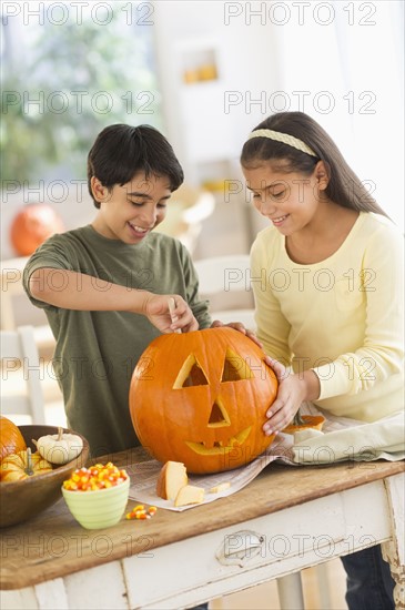 Brother (12-13) and sister (10-11) doing Jack o lantern.