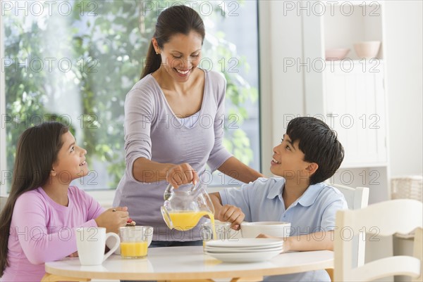 Mother with son (12-13) and daughter (10-11) having breakfast.