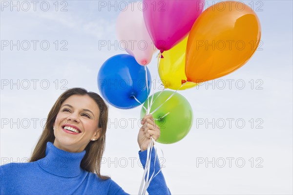 Smiling woman holding balloons.