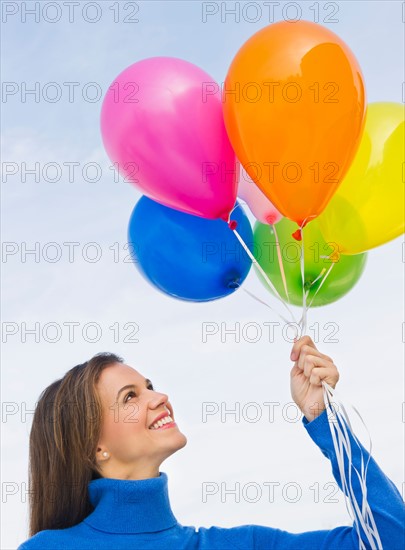 Smiling woman holding balloons.