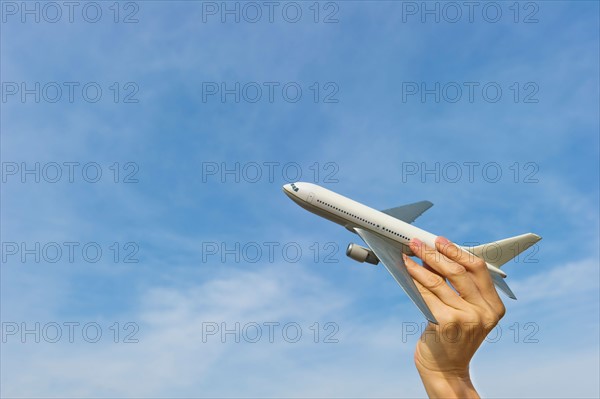 Woman's hand holding plane model.