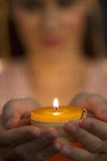 Woman holding tealight.