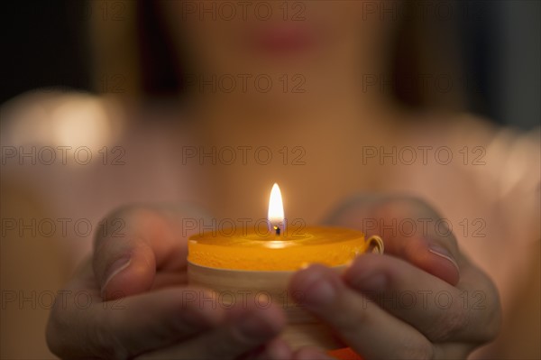 Woman holding tealight.