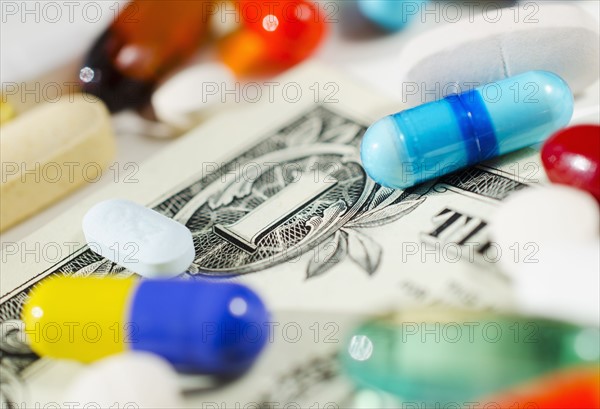 Studio shot of various pills and capsules on one dollar bill.