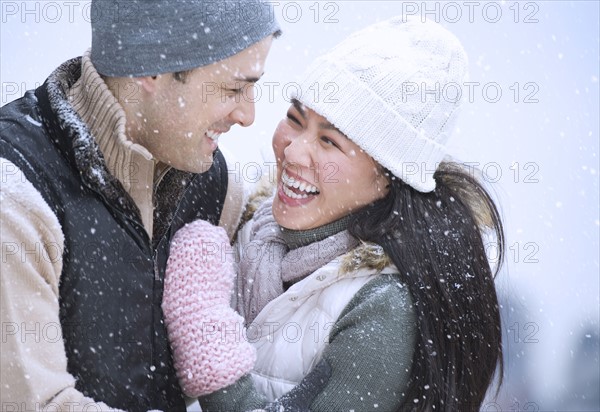 Couple wearing warm clothing having fun outside.