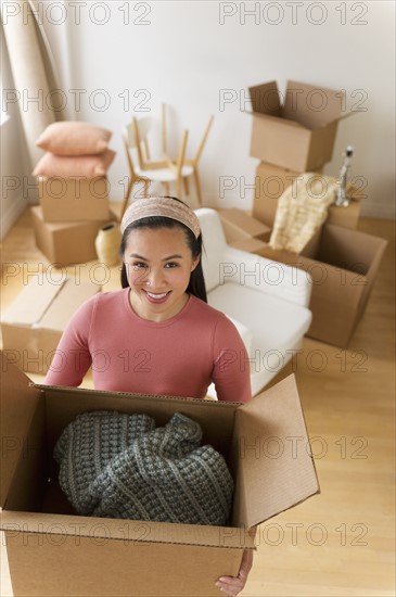 Portrait of woman holding cardboard box.