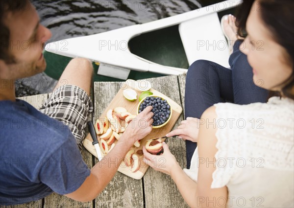 Roaring Brook Lake, Couple eating fruits on pier. Photo : Jamie Grill