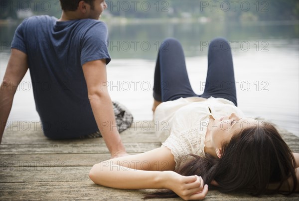 Roaring Brook Lake, Couple lying on pier. Photo: Jamie Grill