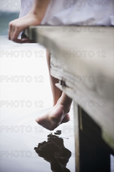 Roaring Brook Lake, Close up of legs of woman sitting on pier by lake. Photo: Jamie Grill