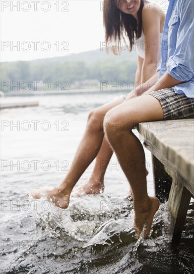 Roaring Brook Lake, Close up of couple sitting on pier by lake. Photo : Jamie Grill
