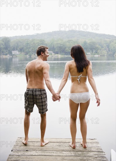 USA, New York, Putnam Valley, Roaring Brook Lake, Couple standing on pier by lake. Photo: Jamie Grill