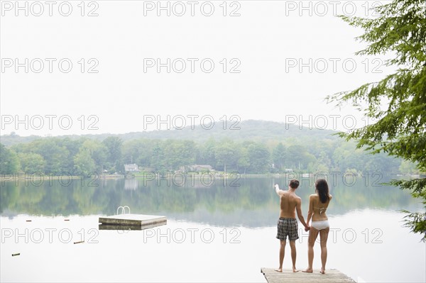 USA, New York, Putnam Valley, Roaring Brook Lake, Couple standing on pier by lake. Photo : Jamie Grill