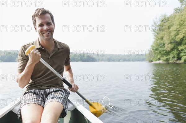 USA, New York, Putnam Valley, Roaring Brook Lake, Man rowing boat. Photo : Jamie Grill