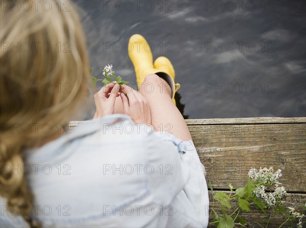 Roaring Brook Lake, Rear view of woman sitting on pier by lake. Photo : Jamie Grill