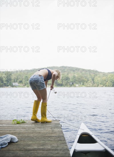 USA, New York, Putnam Valley, Roaring Brook Lake, Rear view of woman mooring boat. Photo : Jamie Grill