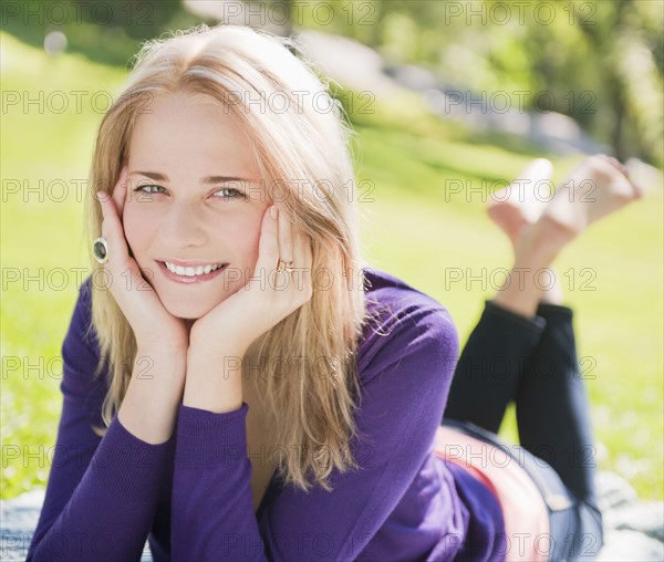 USA, New York, New York City, Manhattan, Central Park, Young woman lying on grass. Photo: Daniel Grill