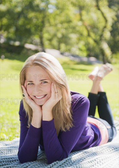 USA, New York, New York City, Manhattan, Central Park, Young woman lying on grass. Photo : Daniel Grill