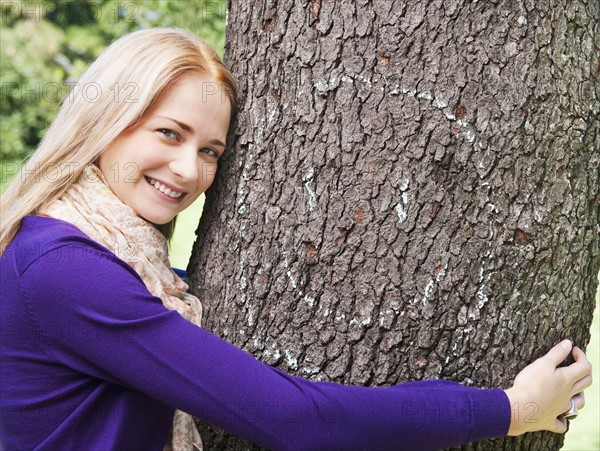 USA, New York, New York City, Manhattan, Central Park, Young woman embracing tree. Photo : Daniel Grill