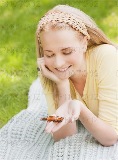 Woman holding butterfly on hand. Photo: Daniel Grill