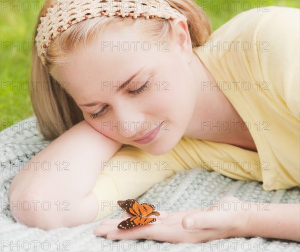 Woman holding butterfly on hand. Photo: Daniel Grill