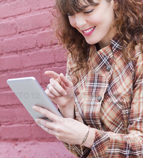 Close up of woman using digital tablet. Photo : Daniel Grill