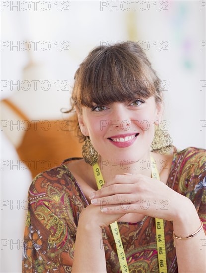 Portrait of smiling female fashion designer . Photo : Daniel Grill