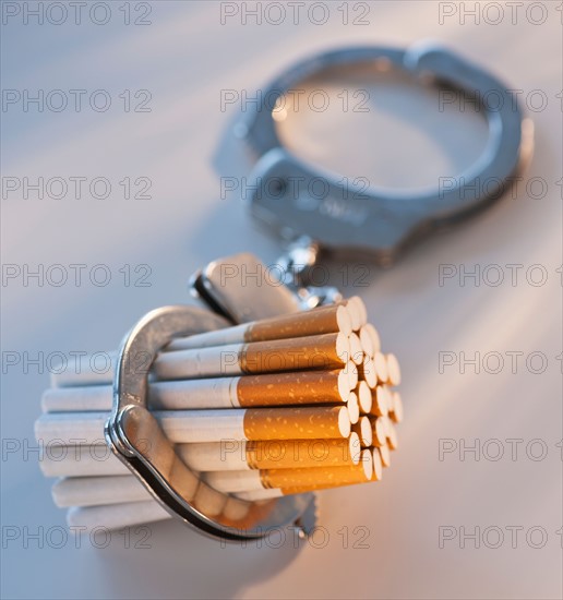 Close up of bunch of cigarettes locked in handcuffs. Photo: Daniel Grill