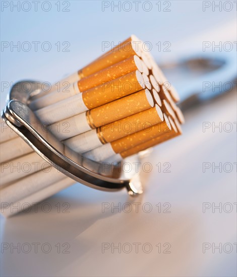 Close up of bunch of cigarettes locked in handcuffs. Photo : Daniel Grill