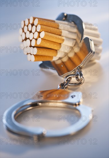 Close up of bunch of cigarettes locked in handcuffs. Photo : Daniel Grill