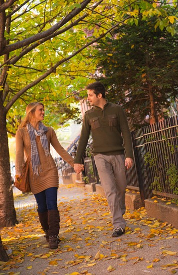 Young couple walking on pavement. Photo : Daniel Grill