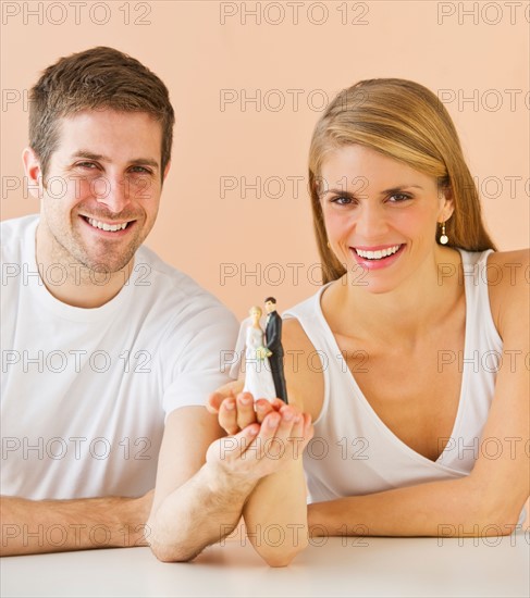 Couple holding small wedding figurine. Photo : Daniel Grill