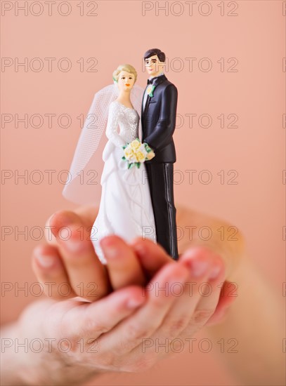 Couple holding small wedding figurine. Photo : Daniel Grill