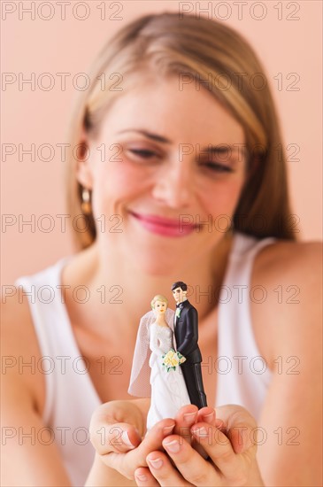 Young woman holding wedding figurine. Photo : Daniel Grill