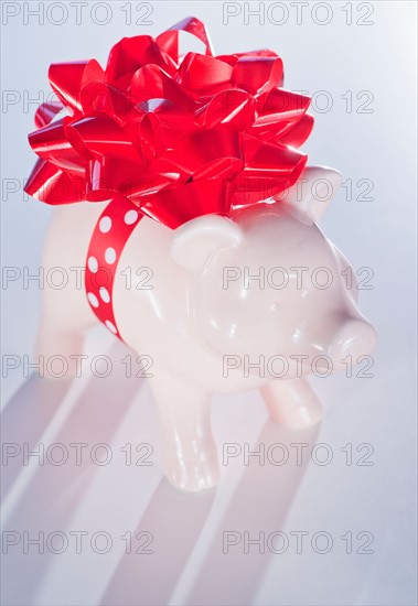 Piggy bank with big red ribbon. Photo : Daniel Grill