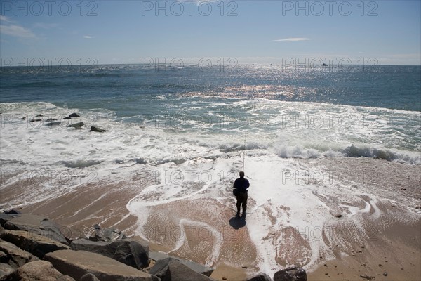 USA, New York, Long Island, Montaurk, Man fishing in sea. Photo : fotog